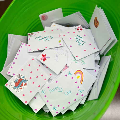 A green bin filled with 200 decorative cards for hospitalized kids.