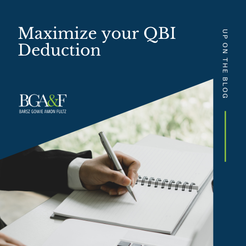 Man using a pencil to write his QBI deductions in a notebook